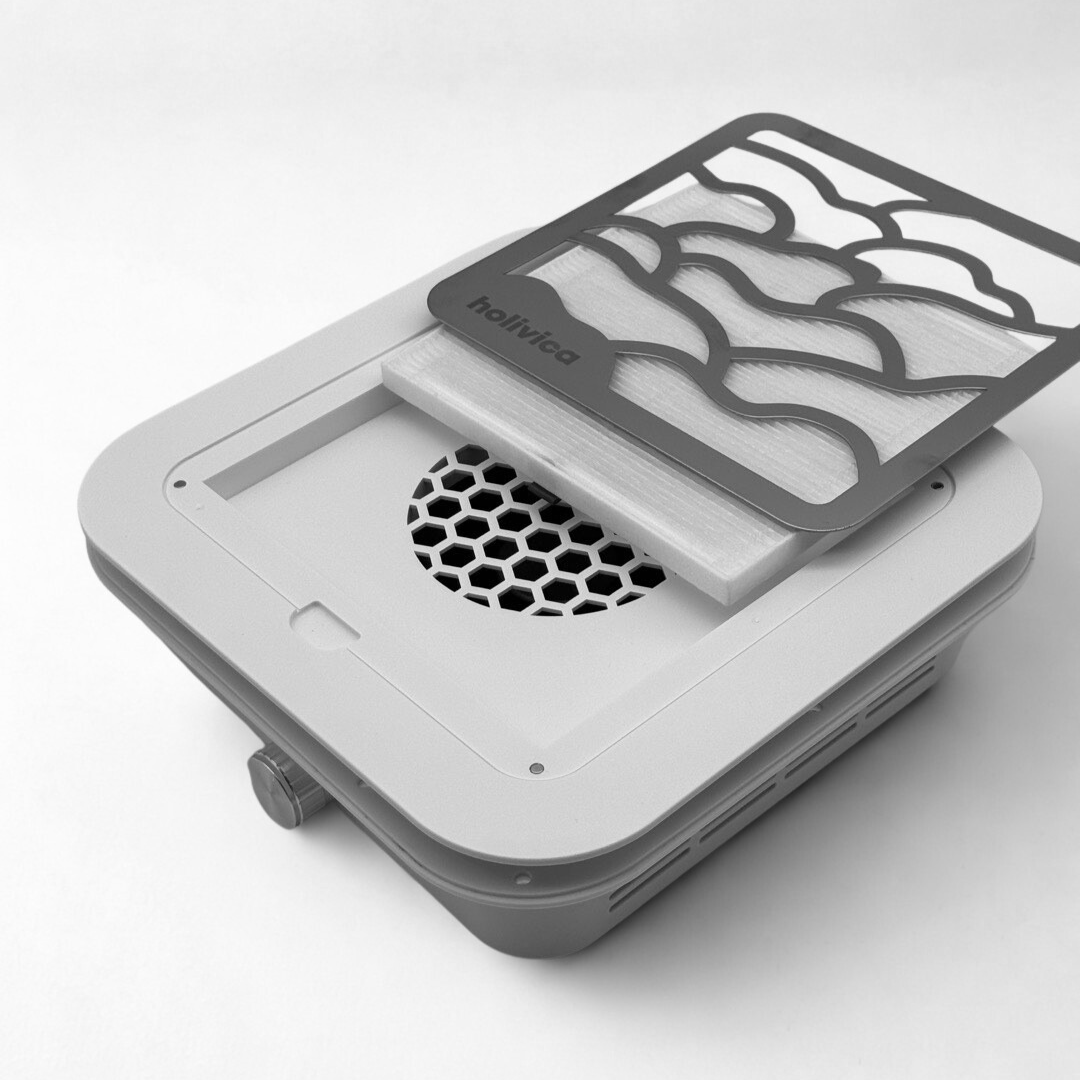 Pochłaniacz pyłu Holivica Pro 2 do zabudowy z otwartą kratką i filtrem HEPA, widoczny wentylator w obudowie.